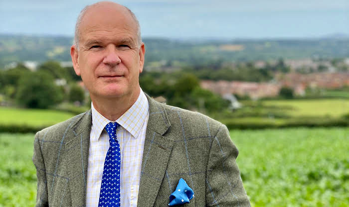 Photo of a man with fields in background.