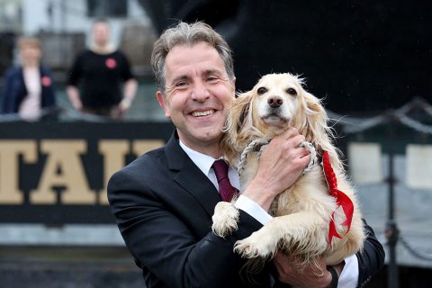 Photo of a man holding a dog.