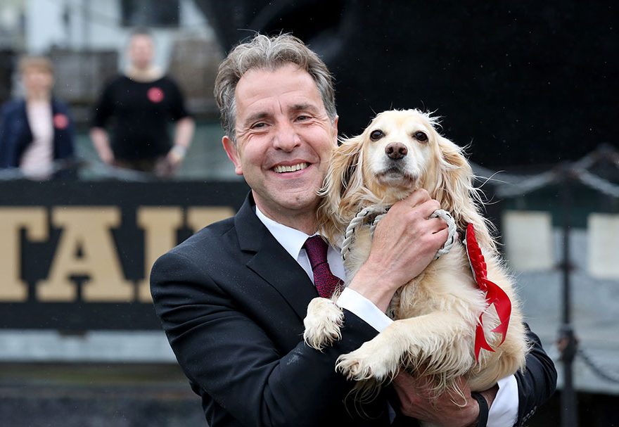 Photo of a man holding a dog.