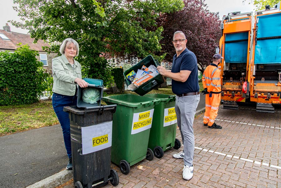 Council leader Cllr Claire Young and co-leader Cllr Ian Boulton at the Page Road car park drop-off site. Photo of two councillors emptying recycling containers into bins.